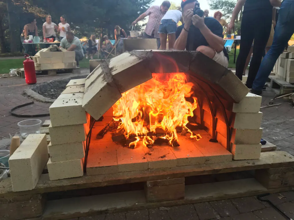 Uczestnik wkłada pizzę do pieca