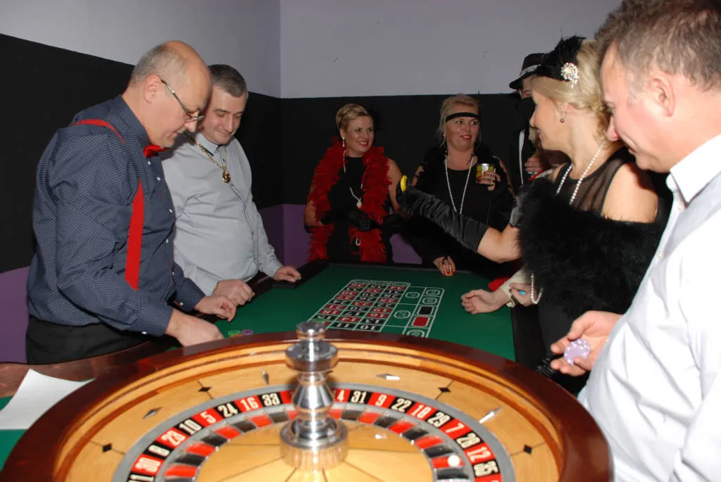 Kobieta w eleganckiej sukni przy stole do ruletki